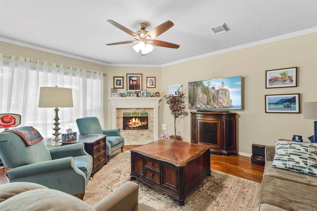 This view of the living room highlights the expansive windows that fill the space with beautiful natural light. The soft neutral tones and inviting fireplace create a perfect blend of warmth and brightness, making this room an ideal spot to relax or entertain.