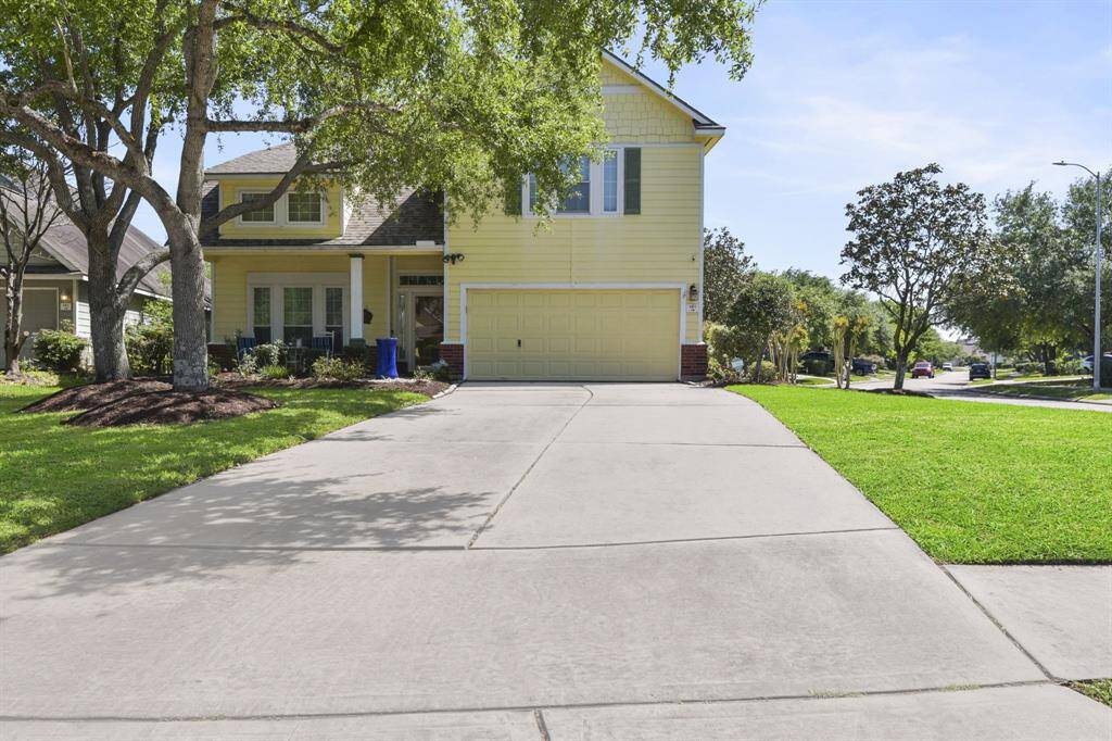 Charming two-story suburban home with a welcoming and well-maintained exterior. The front yard is neatly landscaped, manicured flower beds, and mature trees providing shade.