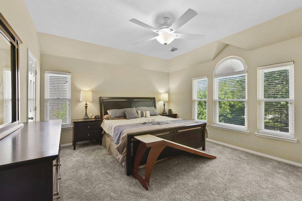 Experience the beauty of natural light flooding this spacious primary bedroom, thanks to a stunning wall of windows that offer breathtaking views of the outdoors. The generous layout provides ample room to unwind, while the expansive windows create a serene and airy atmosphere, making this room a perfect sanctuary for relaxation.