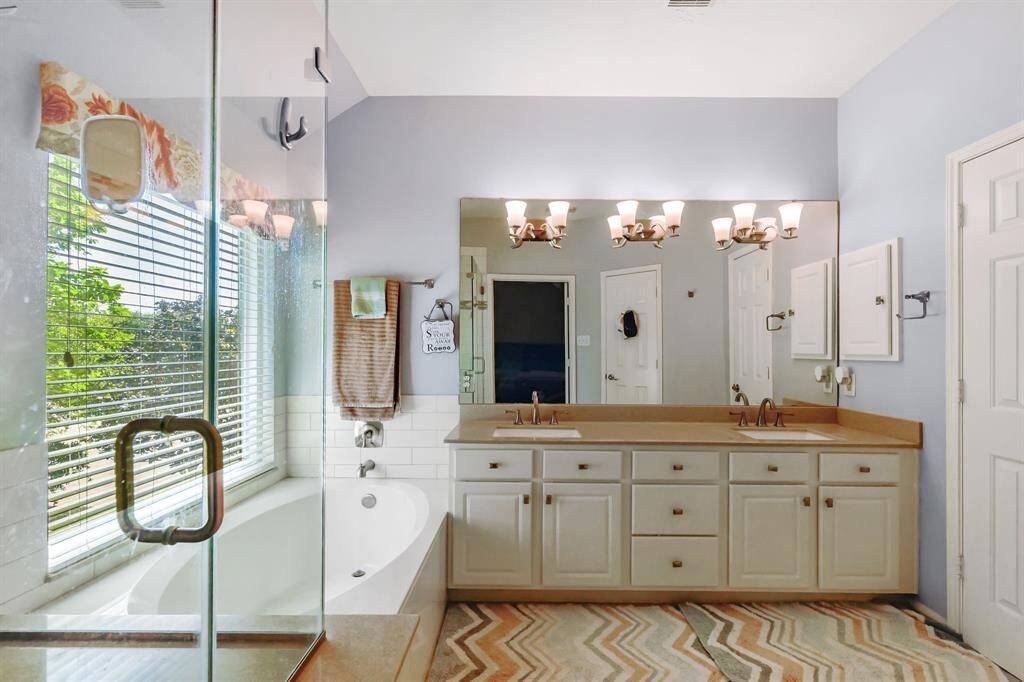 Indulge in the luxury of this spacious primary bathroom, featuring double sinks for added convenience and style. The separate tub offers a relaxing retreat, while the seamless shower provides a modern, sleek design. With elegant finishes and plenty of space, this bathroom creates a serene and spa-like atmosphere for ultimate comfort and relaxation.