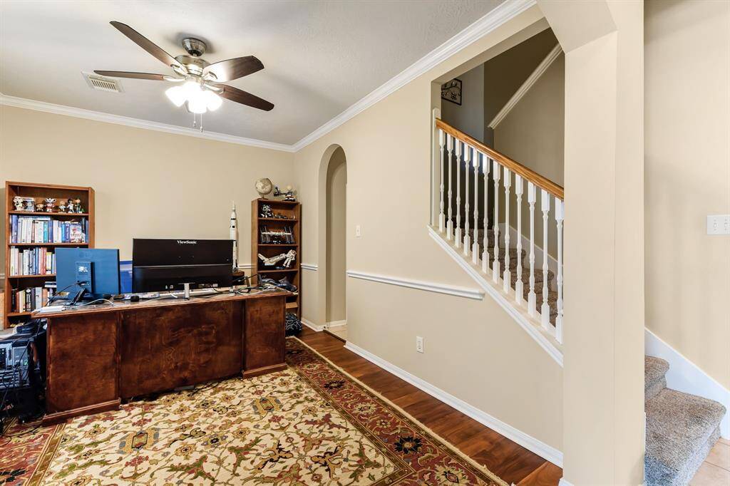 Another view reveals the formal area flowing seamlessly toward the kitchen, creating a natural connection for entertaining or everyday living. Just beyond, a staircase leads upstairs to all the bedrooms, offering a thoughtful layout that balances function and comfort.