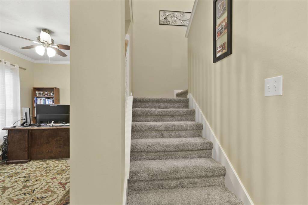This view showcases the staircase leading to the upper level, where all bedrooms and the spacious game room are located. The neutral palette continues upstairs, complementing the clean lines and inviting feel of the home’s layout. Perfect for privacy and fun, the second floor is ideal for both restful retreats and lively gatherings.