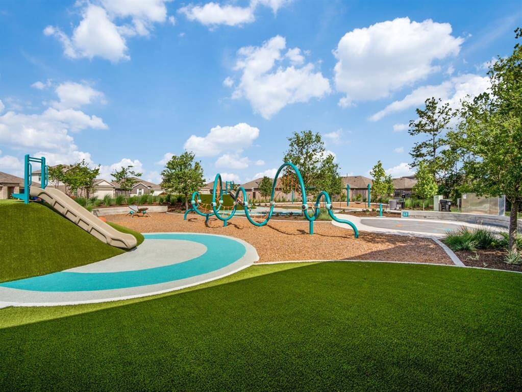 A vibrant community playground featuring a slide, modern climbing structures, and well-maintained green spaces. Perfect for families and outdoor activities.