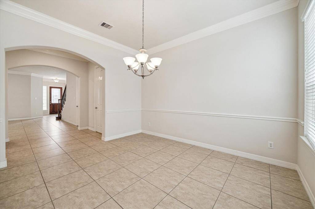 Enhanced by an exquisite light fixture that beautifully illuminates the space, the formal dining room is just steps from the gourmet kitchen and main living area—perfectly suited for modern living and effortless entertaining.
