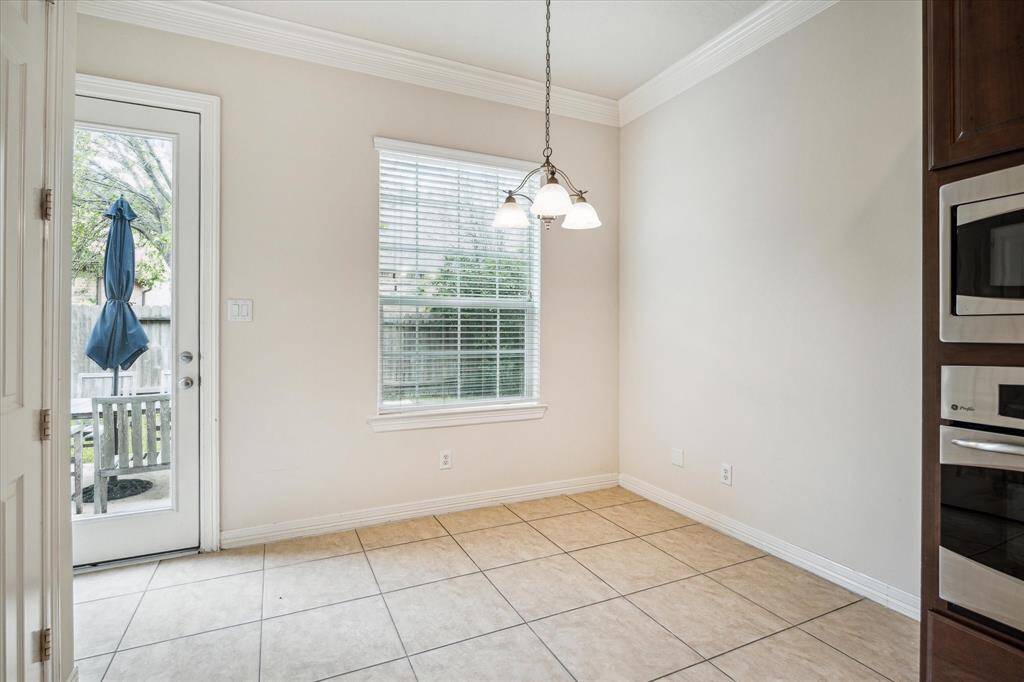 Just a few steps from the gourmet kitchen, the breakfast area is filled with abundant natural light and enhanced by an exquisite light fixture for added ambiance. It also offers direct access to the backyard, making it a bright and convenient space for everyday dining.