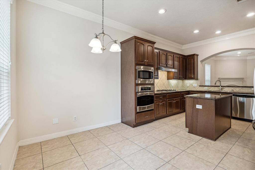 Nestled beside the island kitchen, the breakfast room is the perfect spot for casual dining and relaxed morning gatherings. Enjoy your meals while taking in the beautiful views of the backyard, creating a serene and inviting atmosphere.
