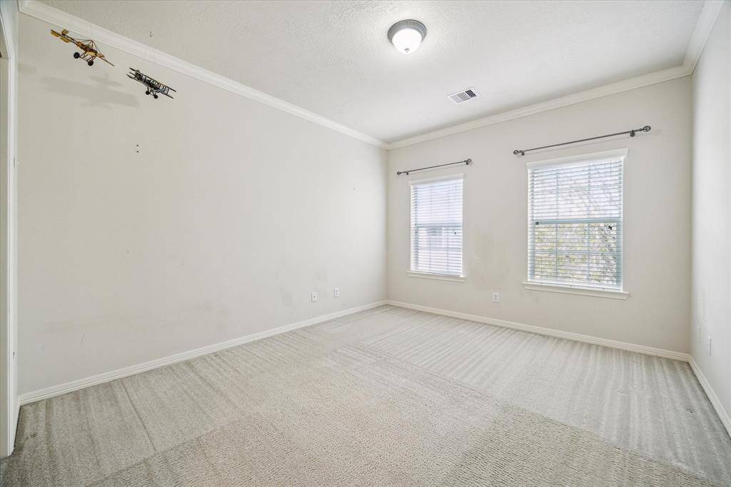 The secondary bedroom, located on the second level, offers stunning views of the backyard. This spacious retreat also enjoys convenient access to a shared hallway bath, making it both comfortable and functional.