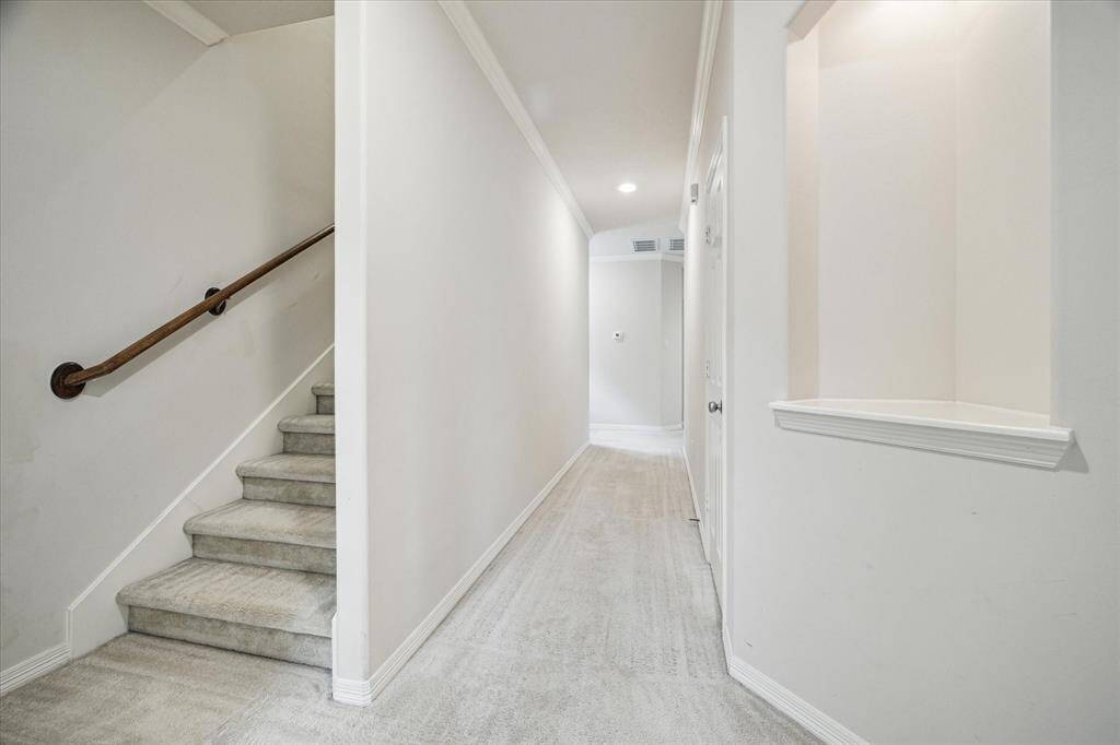The second-level hallway features a calming neutral palette and an alcove ideal for adding decorative touches or personalized design embellishments, enhancing the space with both charm and character.