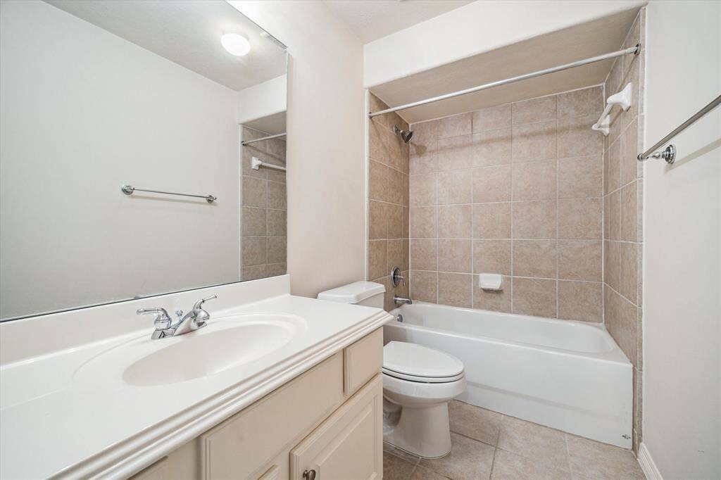 The common bath for the game room is well-appointed with a spacious vanity offering ample storage, complemented by a sleek tub-shower combo—perfectly blending convenience and functionality.