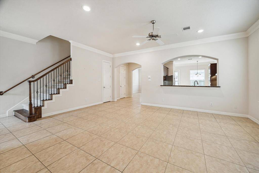 The expansive main living area offers direct access to the formal dining room and features a pass-through counter that provides a clear view into the gourmet kitchen, enhancing the flow and connectivity.