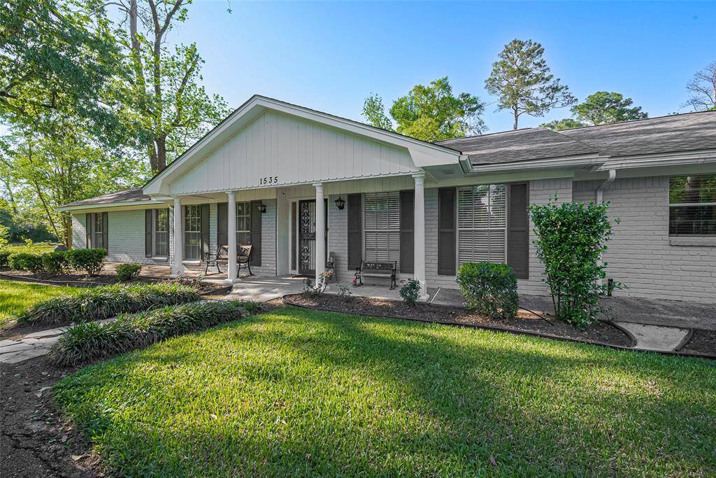 Spacious backyard featuring a covered patio with power, lighting, and ceiling fans—ideal for entertaining.