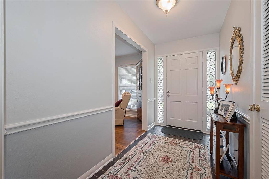 Elegant entryway leading to the formal dining room, living room, and cozy den.
