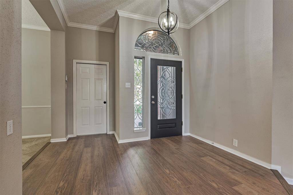 Entryway adorned with an impressive glass leaded front door with arched transom and sidelite
