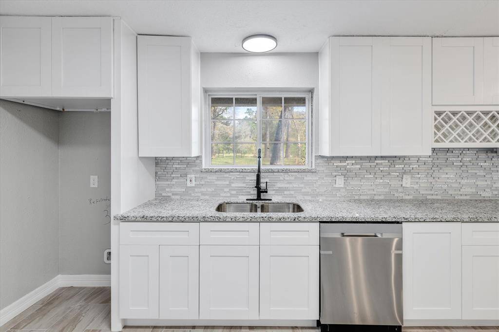 Stylish cabinetry and top of the line appliances including a sink, a dishwasher, and an oven/stovetop.