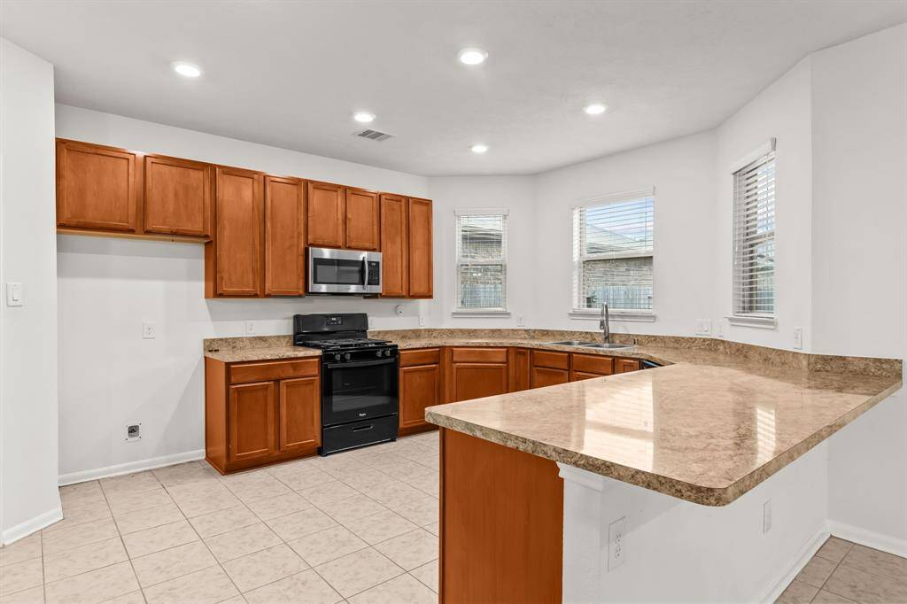 Lots of windows recessed lighting making the kitchen bright and cheery with recessed and natural lighting  for that rainy day