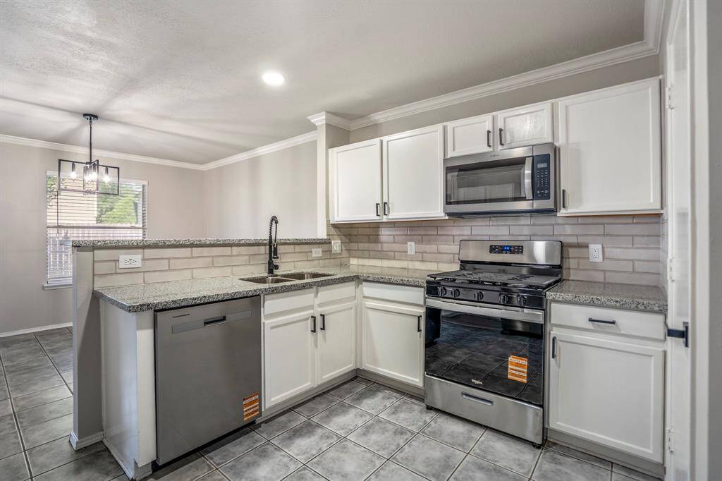 The kitchen has been updated with granite countertops, freshly painted cabinets, updated hardware, a new sink and faucet — and yes, the refrigerator is included!