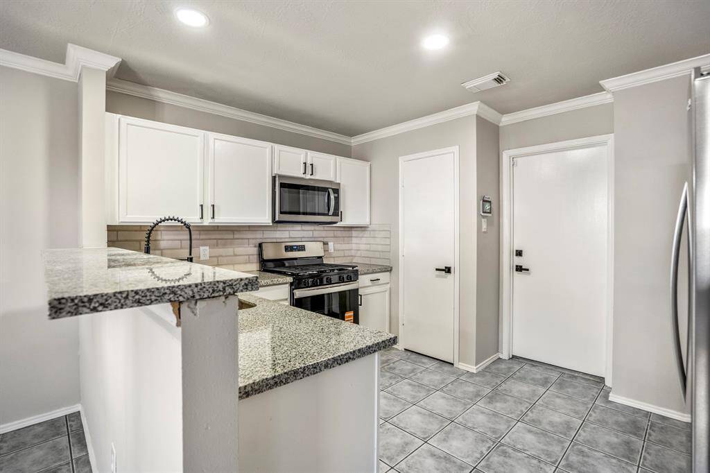 The kitchen has been updated with granite countertops, freshly painted cabinets, updated hardware, a new sink and faucet — and yes, the refrigerator is included!