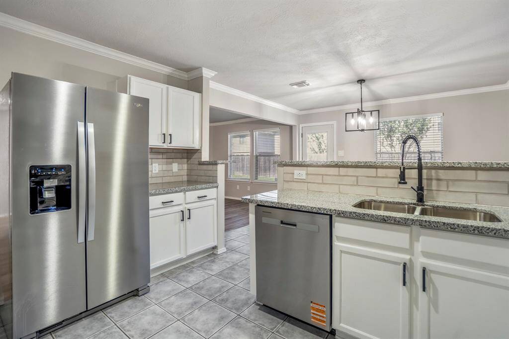 The kitchen has been updated with granite countertops, freshly painted cabinets, updated hardware, a new sink and faucet — and yes, the refrigerator is included!