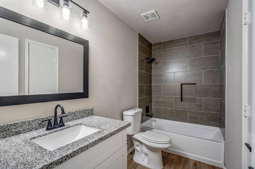 The secondary bathroom has been fully updated with new plumbing, wall tile, vanities, mirrors, granite countertops, and modern faucets