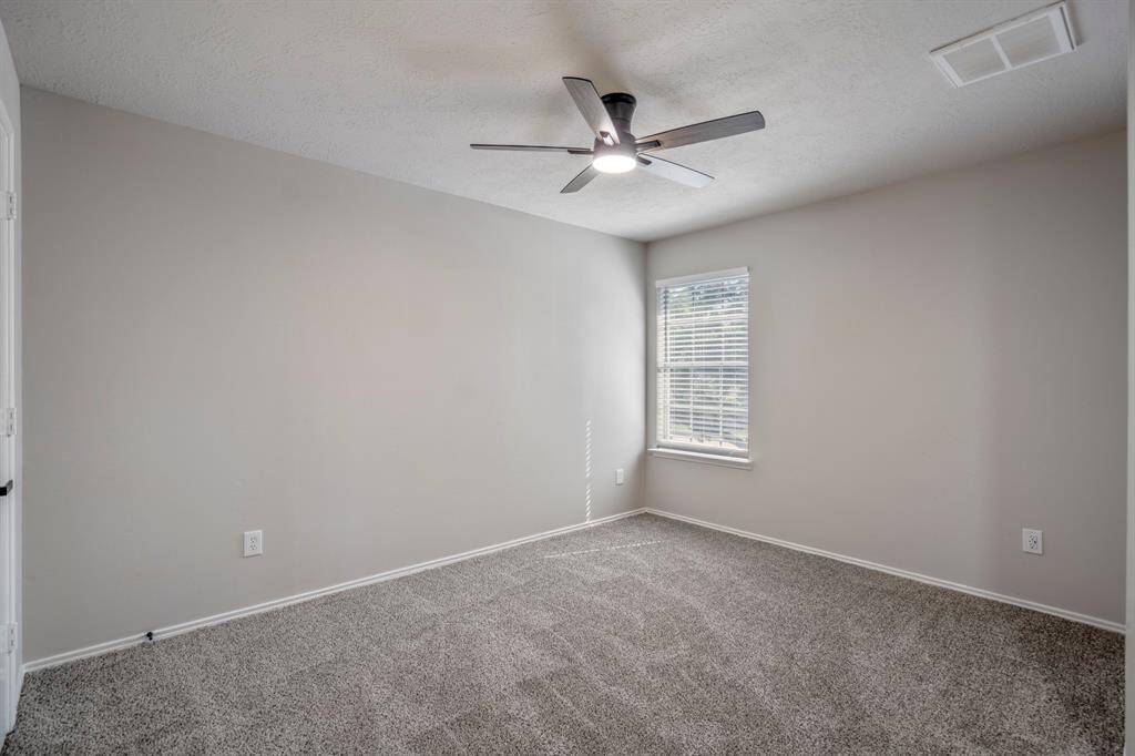 The primary suite has been refreshed with new flooring, a modern ceiling fan, and a fresh coat of paint, creating a calm and inviting retreat.