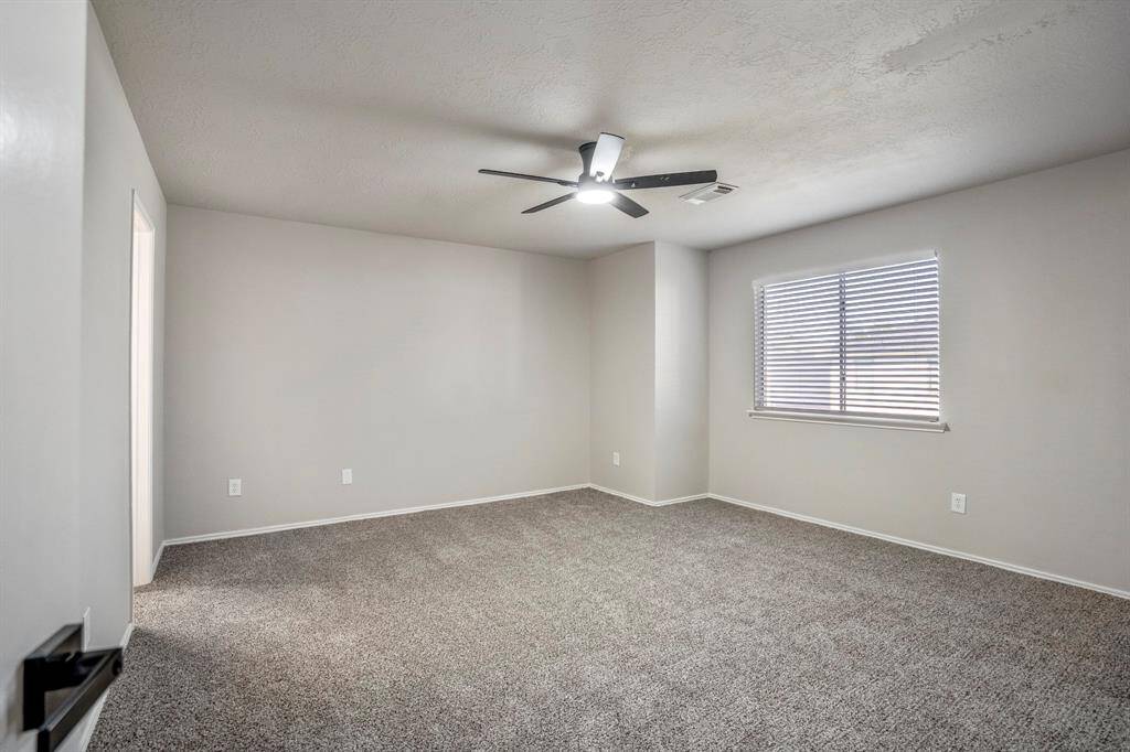 The primary suite has been refreshed with new flooring, a modern ceiling fan, and a fresh coat of paint, creating a calm and inviting retreat.