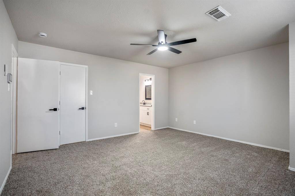 The primary suite has been refreshed with new flooring, a modern ceiling fan, and a fresh coat of paint, creating a calm and inviting retreat.