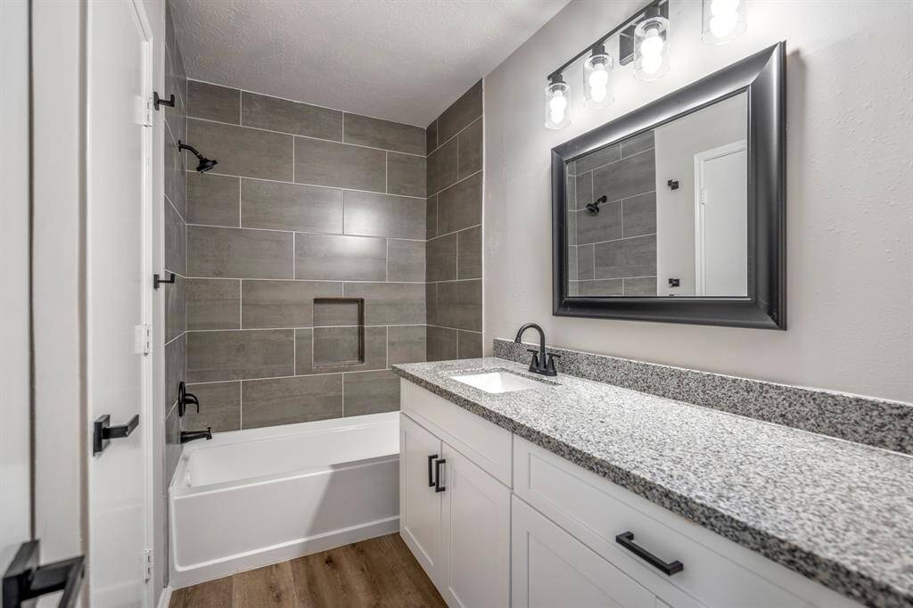 No detail was overlooked in the primary bathroom renovation — from updated plumbing and designer tilework to granite-topped vanities, framed mirrors, and elegant new faucets.