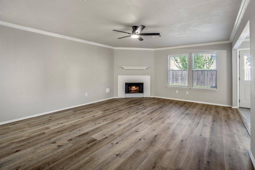 The living room is spacious and features a modern gas fireplace, new flooring, paint and light/fan fixture.