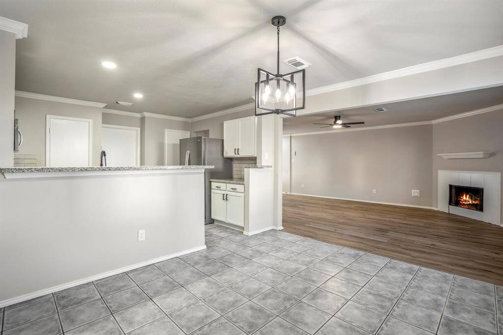The dining area offers a seamless view into both the kitchen and living room, creating an open and connected feel.