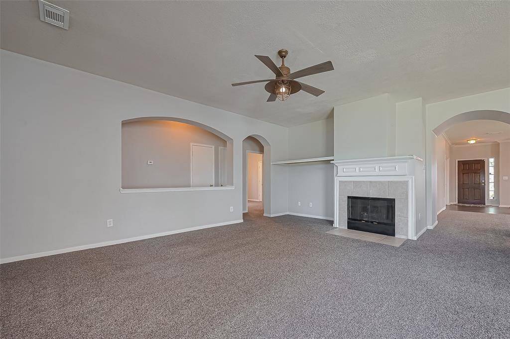 Family room features a fireplace and a tv nook and a view of the front entry.
