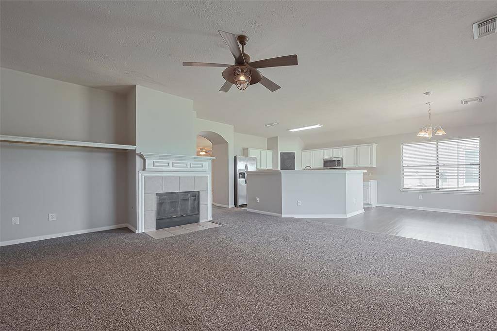 Large open kitchen with stainless steel appliances, refrigerator included and luxury vinyl flooring.