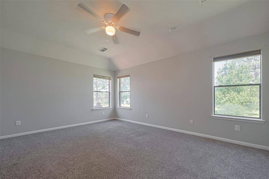 Primary bedroom has plenty of windows with views of the backyard and lake.