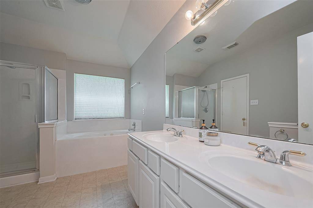 Separate shower and jetted tub with window overlooking the backyard.