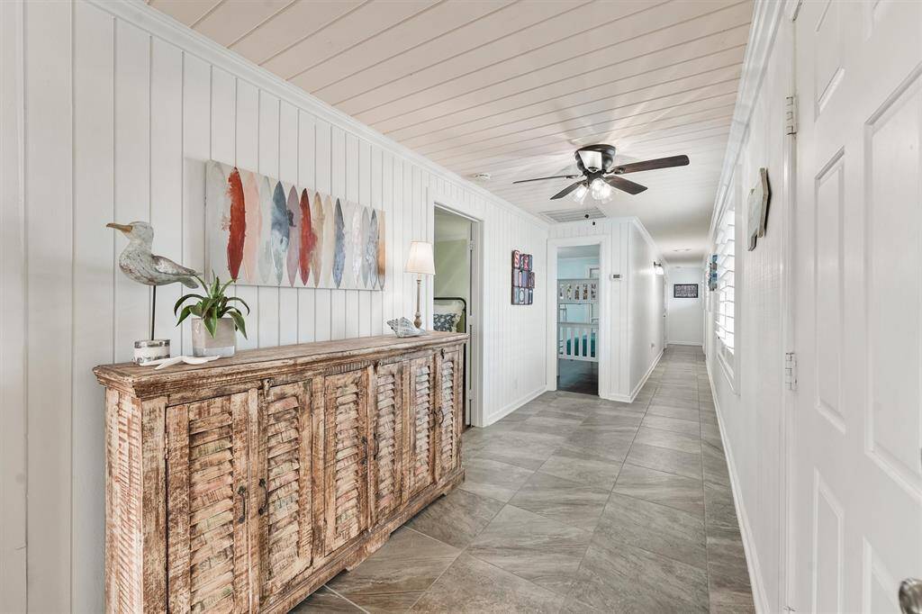 The entry seamlessly connects the home’s living areas, bedrooms and showcases charming accents, shiplap walls, and a stylish rustic console for added character.