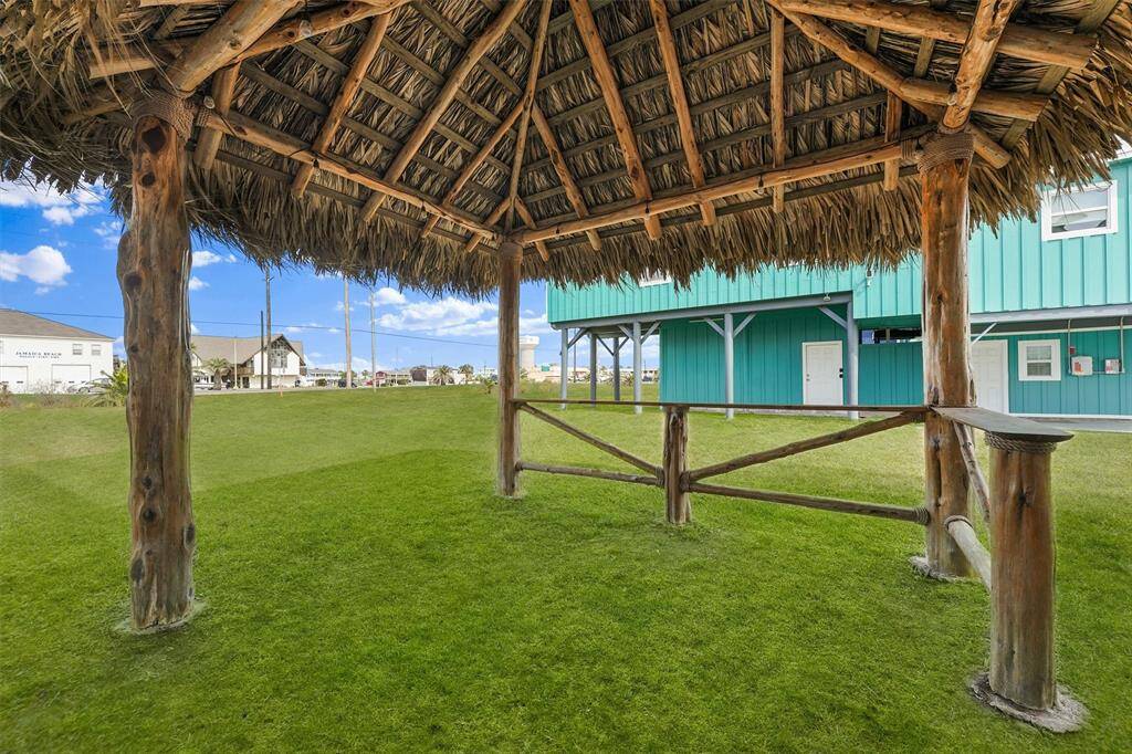 This spacious backyard features a newly added charming Palapa-style tiki hut, perfect for outdoor entertaining and relaxing. With lush green space and ample room for gatherings, this unique addition enhances the tropical charm of this Jamacia Beach retreat.