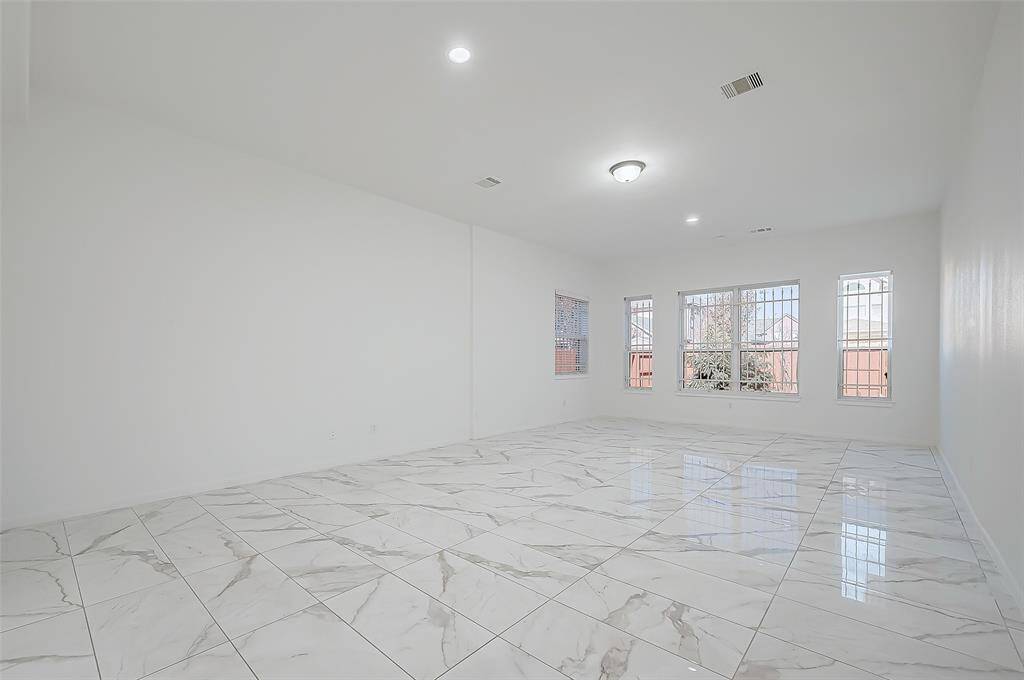 Primary Bedroom (Downstairs): Spacious and filled with natural light. The remodeled primary bathroom includes double vanities, a modern freestanding tub, a walk-in shower, and a large closet with shelving and hanging racks.