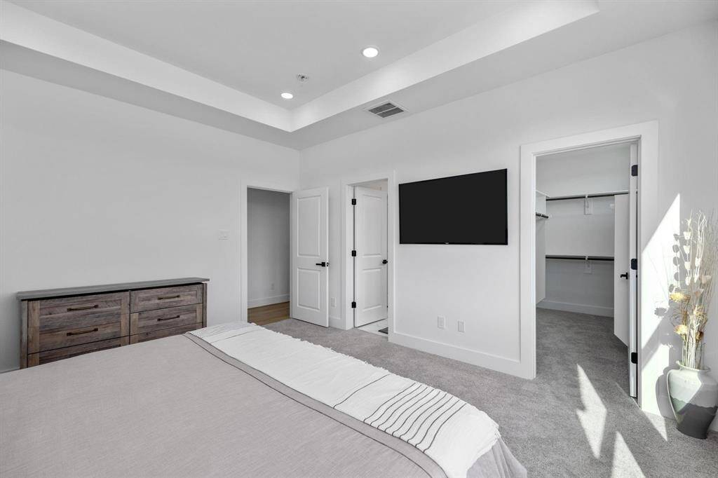 Spacious primary suite with abundant natural light and tray ceiling