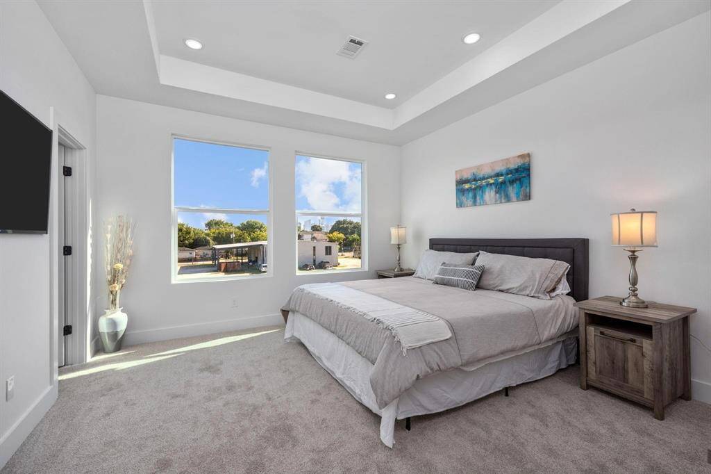 Spacious primary suite with abundant natural light and tray ceiling