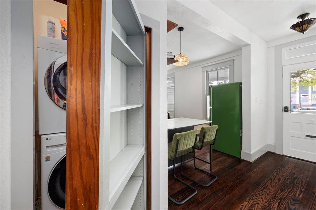 This photo showcases a cozy interior with a stacked washer and dryer hidden behind a sliding bookshelf.