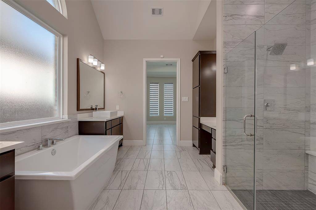 The ensuite bathroom offers the ultimate retreat, complete with a freestanding soaking tub, double vanities with classy framed mirrors, and an extra large mudset shower!