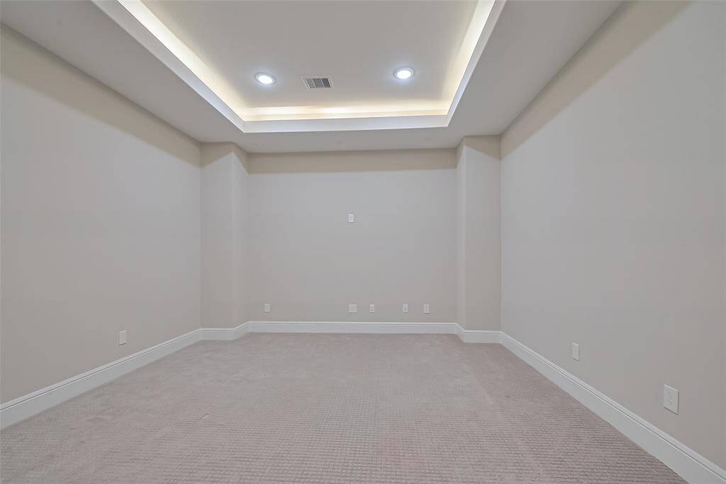The media room is pre-wired for surround sound, and features tray ceilings with lights, providing the perfect setting for movie nights.