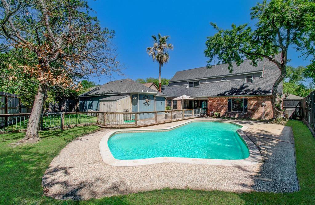Expansive backyard oasis featuring a sparkling pool, fully fenced for added safety.