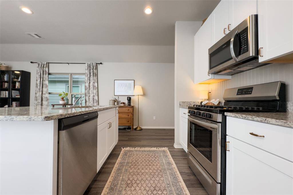 Check out this gorgeous kitchen featuring 42' white kitchen cabinets, updated gold hardware, updated backsplash, granite countertops, and freshly painted island that pulls everything together perfectly.