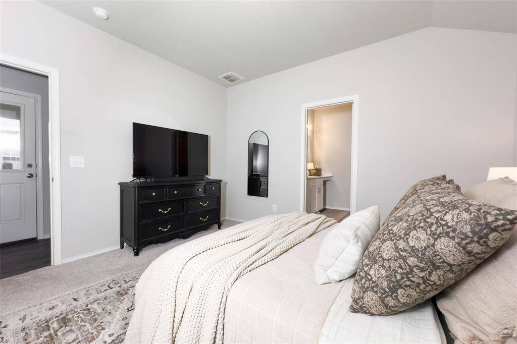 The primary bedroom is tucked away at the back of the home, giving you a peaceful view of the mature trees located at the back of the home.