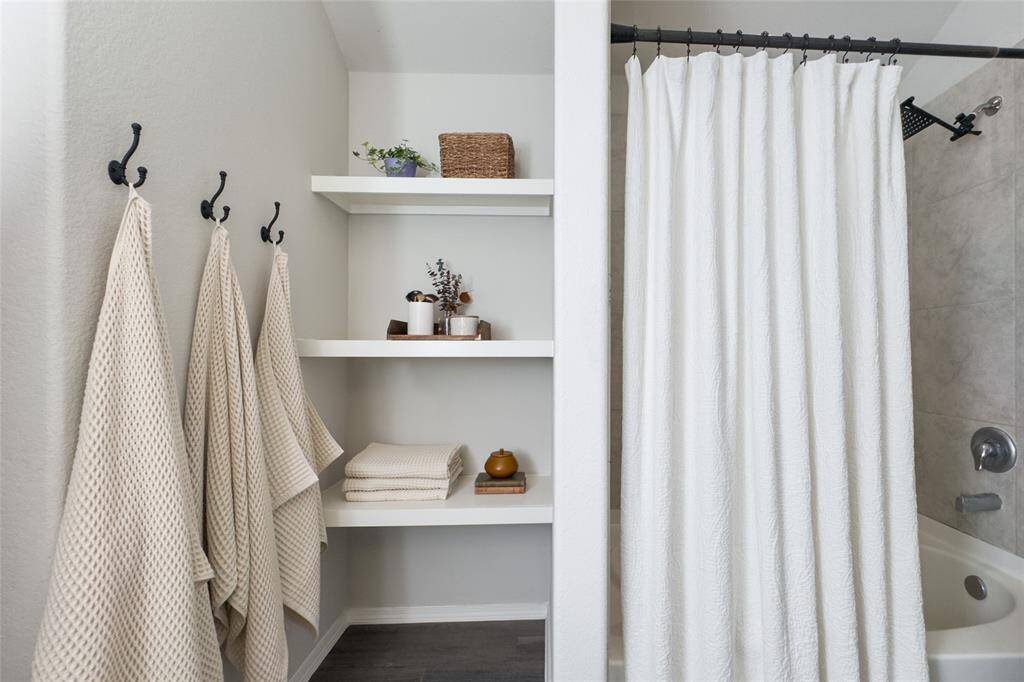 The primary bathroom offers plenty of space, updated shower head, good size closet, and built-in shelves that are perfect for storage.