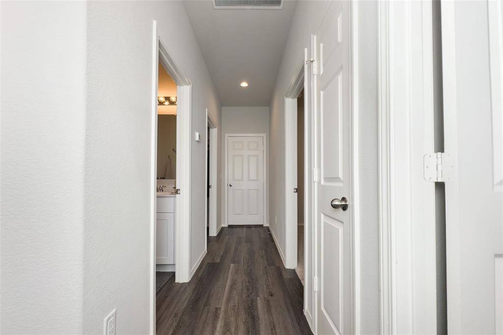 On the opposite side of the home, you'll find the two additional bedrooms, hallway bathroom, and utility room.