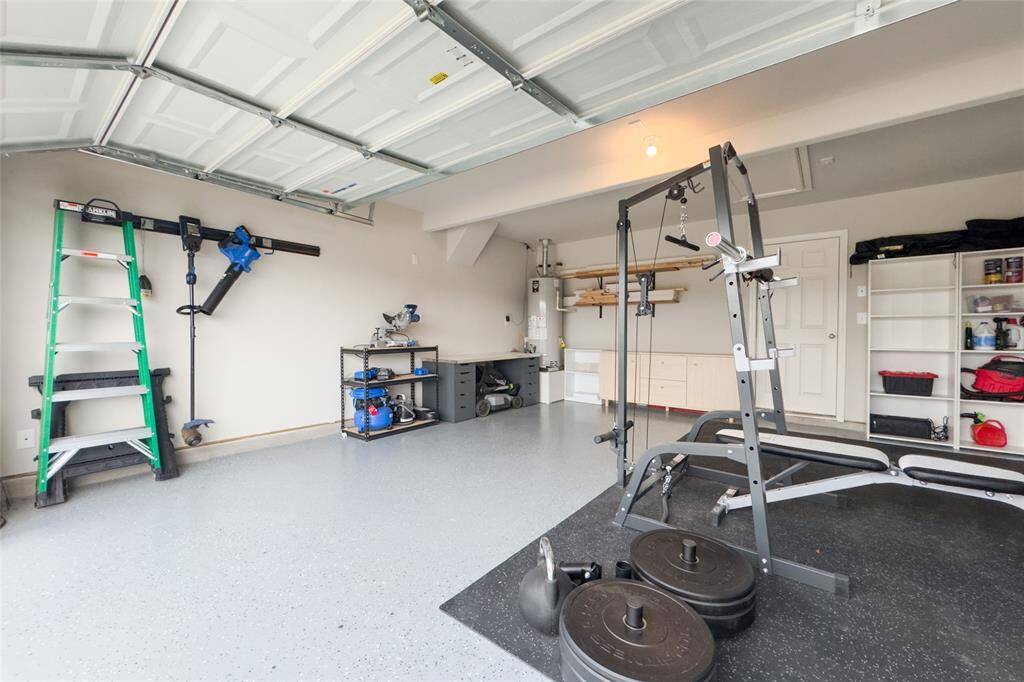 The two car garage features newly finished epoxy flooring and built in shelves.