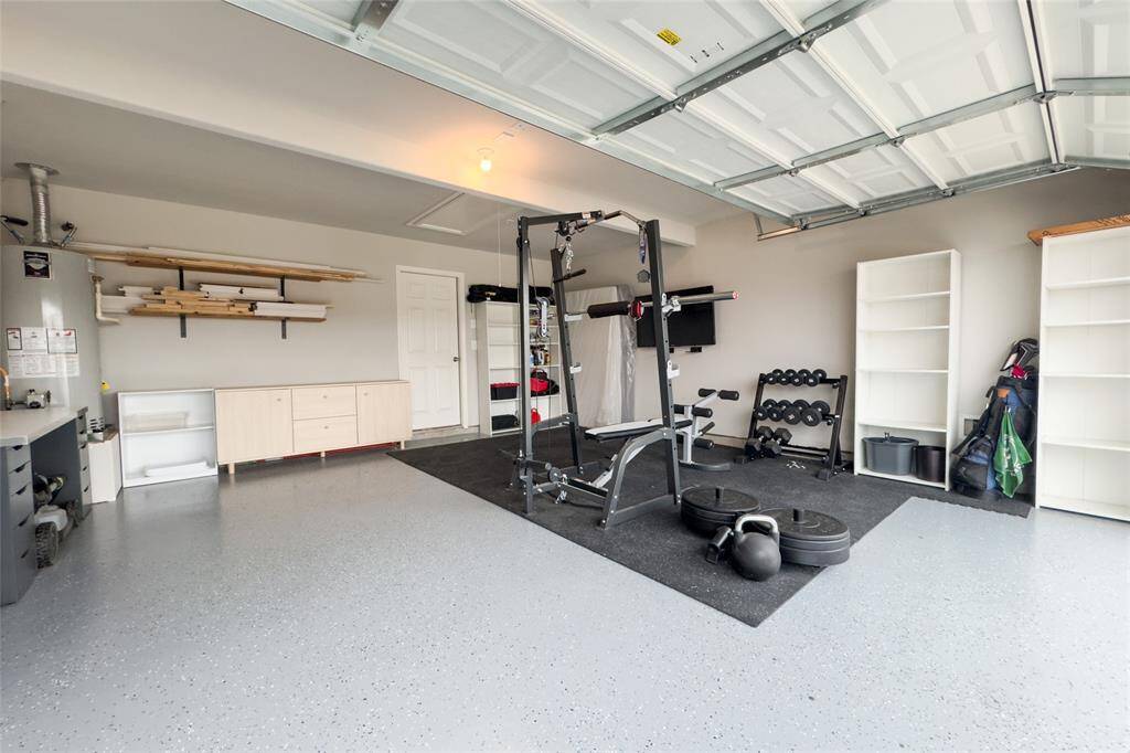 The two car garage features newly finished epoxy flooring and built in shelves.
