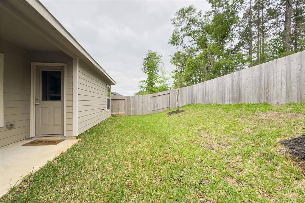 The home features a covered patio overlooking a beautiful scenery and mature trees.