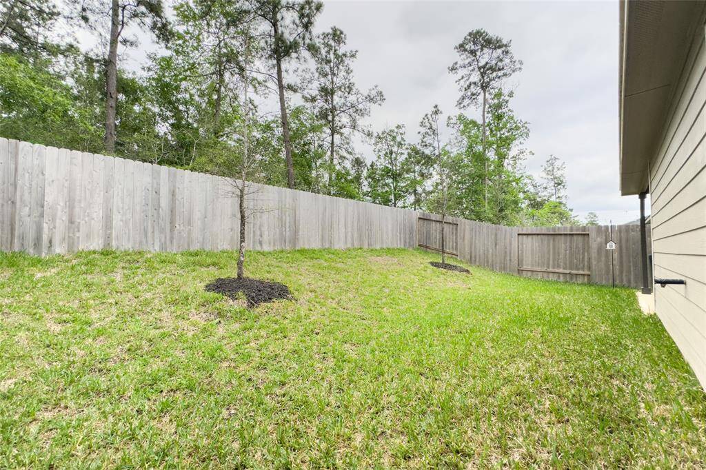 The home features a covered patio overlooking a beautiful scenery and mature trees.